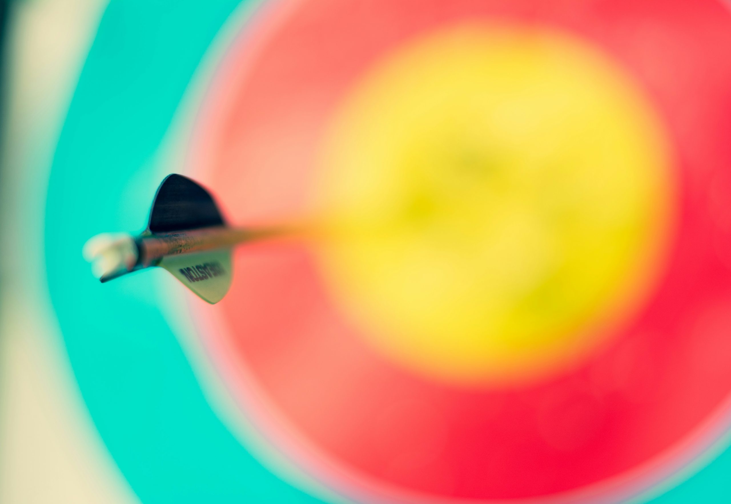 A close-up of an arrow hitting the bullseye of a colorful archery target, emphasizing that specificity in RFPs leads to more accurate, relevant, and successful agency responses.