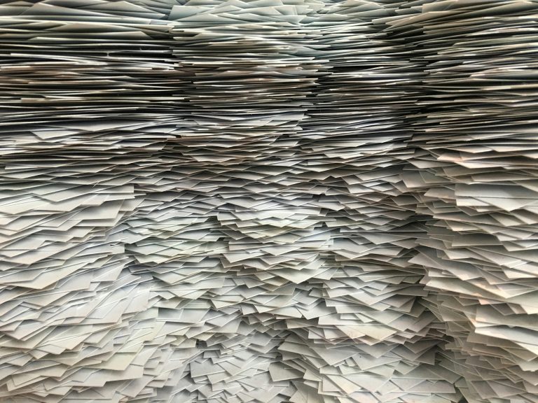 Stacks of paper files illustrating organizational complexity that slows enterprise AI adoption