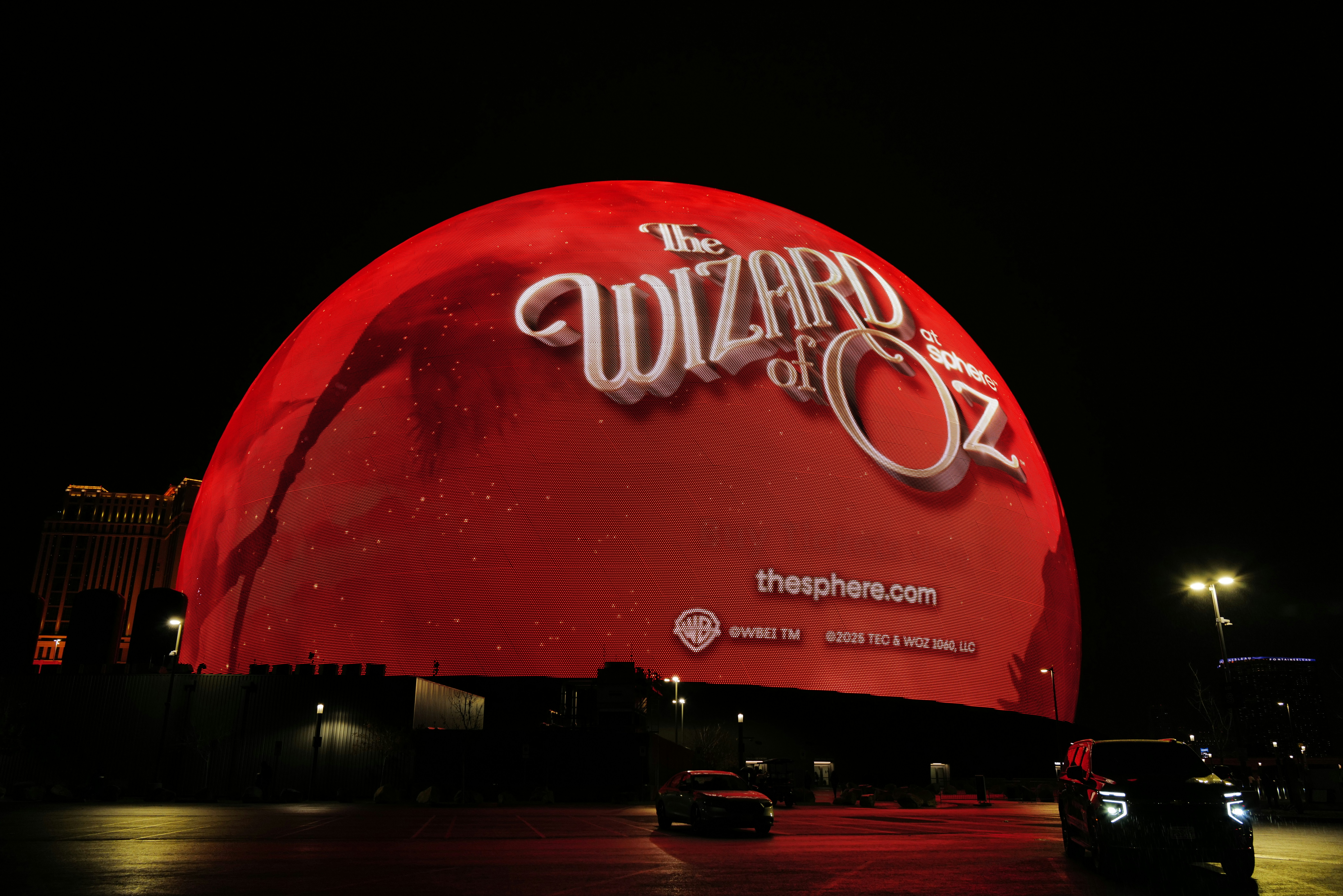 The Sphere’s exosphere wrapped with promotional visuals for ??? ?????? ?? ??, highlighting the economics of immersive content when one Sphere becomes a network.