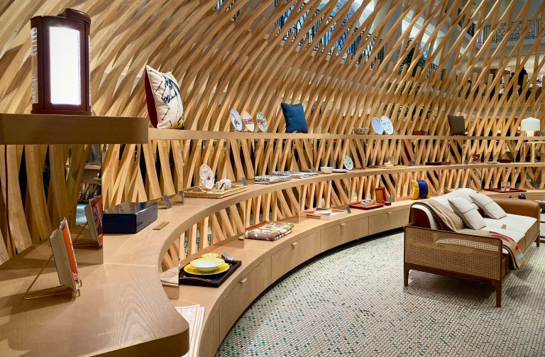 Interior of Hermès Maison on rue de Sèvres in Paris, showing a curated display of luxury items in a sculptural retail environment that reflects abundance and choice